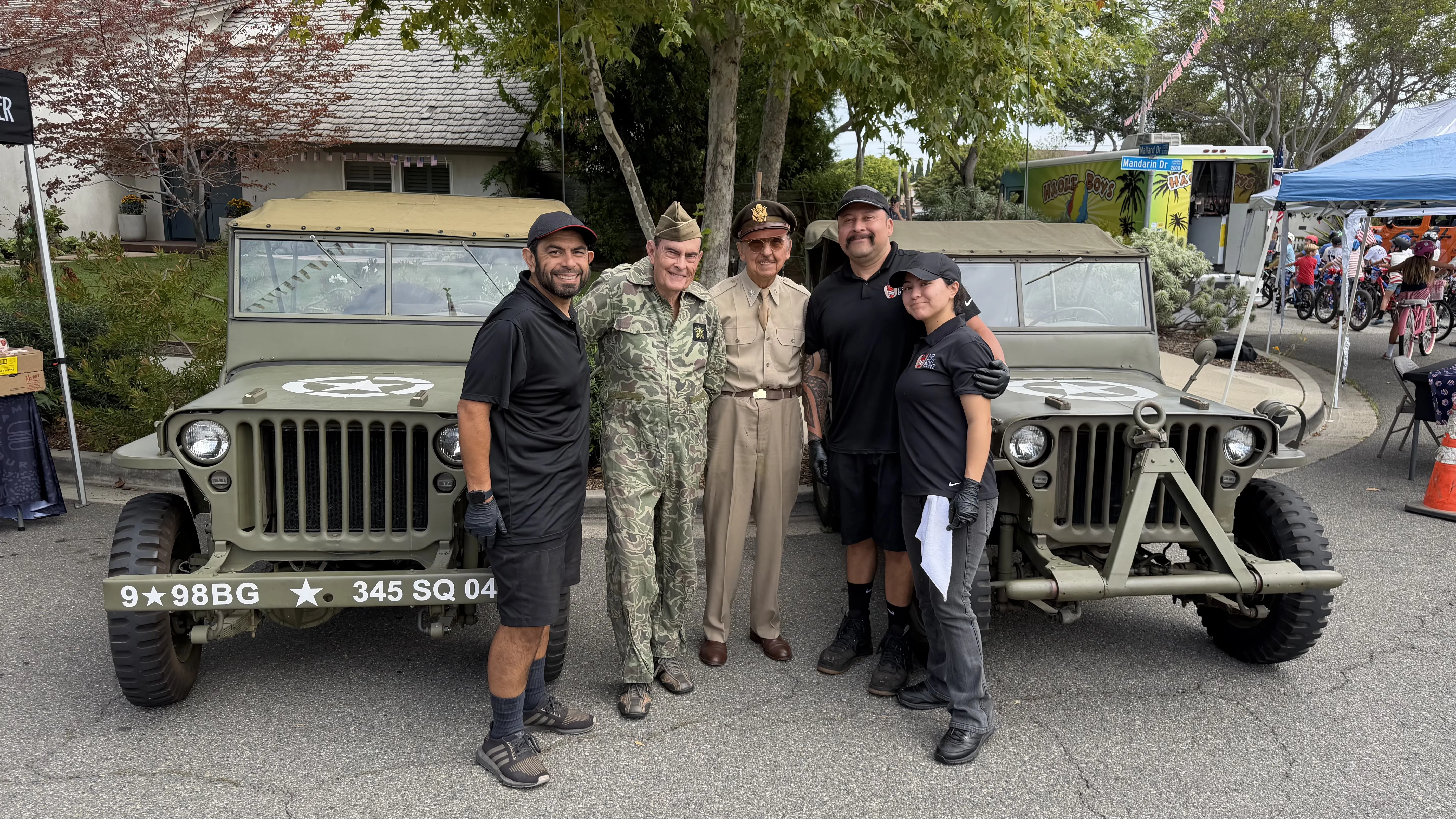 The Mr. Hot Bunz crew posing with vintage military jeeps at a community event